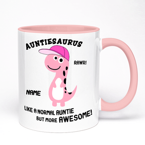 A pink ceramic mug with a whimsical design featuring a dinosaur character with the text 'AUNTIESAURUS' and the option to customize a name and add a message.